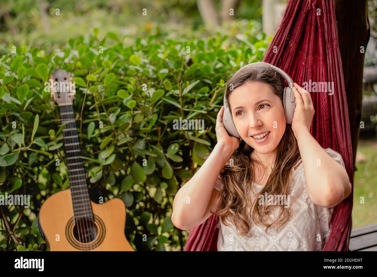 Une femme heureuse écoute de la musique dans un hamac Banque D'Images