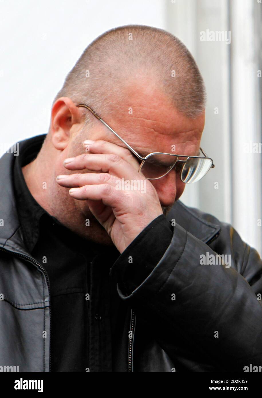 Petre Cozma, the father of slain Romanian handball player Marian Cozma of  MKB Veszprem, wipes his tears outside Dinamo club in Bucharest,February 13,  2009. Cozma was stabbed to death and two other