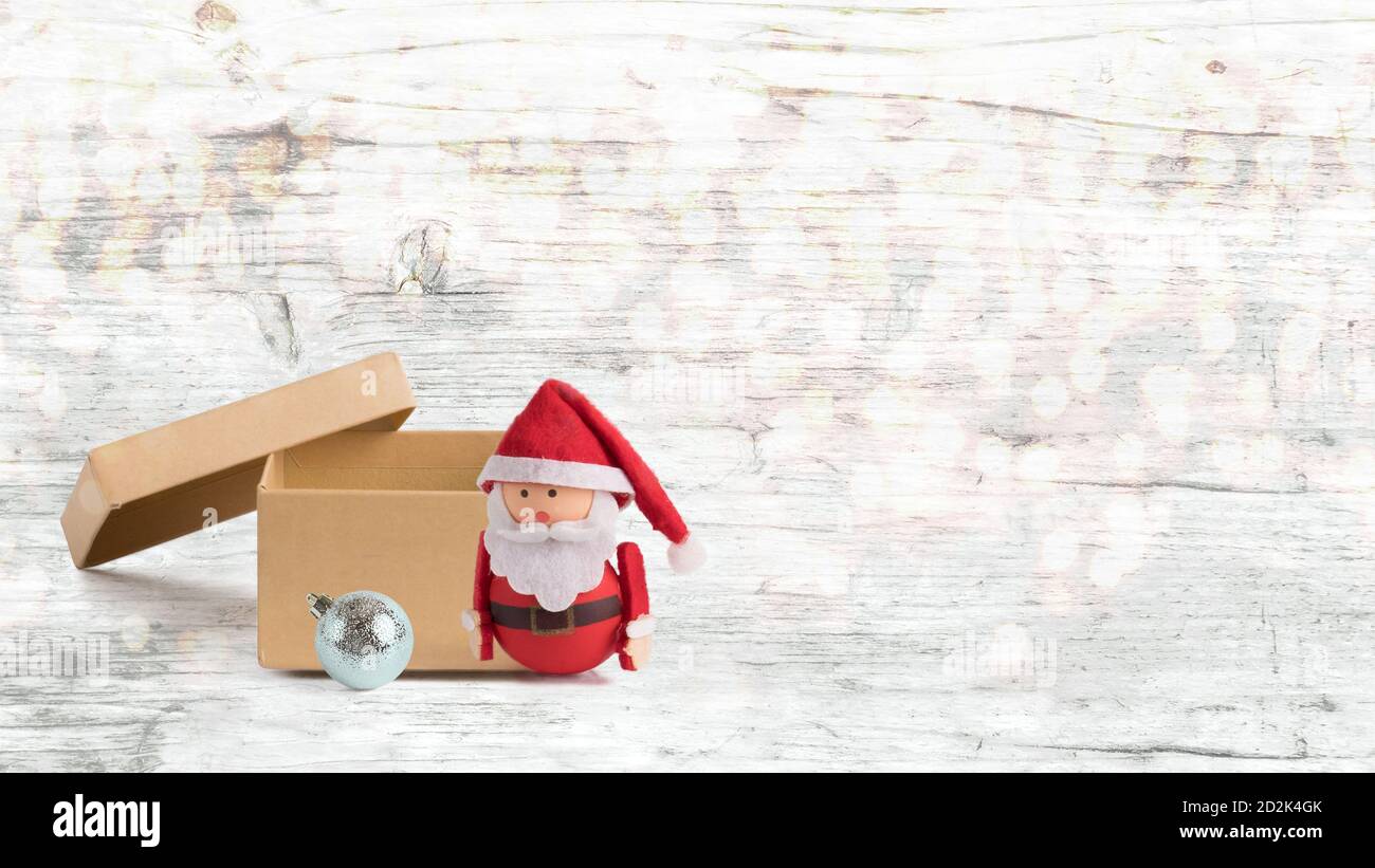 Bannière, toile de fond ou arrière-plan avec une jolie poupée du Père Noël et une boîte ouverte avec espace de copie et bokeh. Convient aux cartes de Noël. Christma isolé Banque D'Images
