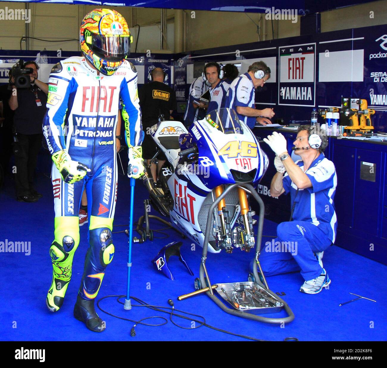 Yamaha MotoGP rider Valentino Rossi of Italy walks to his bike with the aid  of a crutch during a free practice for the German Grand Prix at the  Sachsenring circuit near the