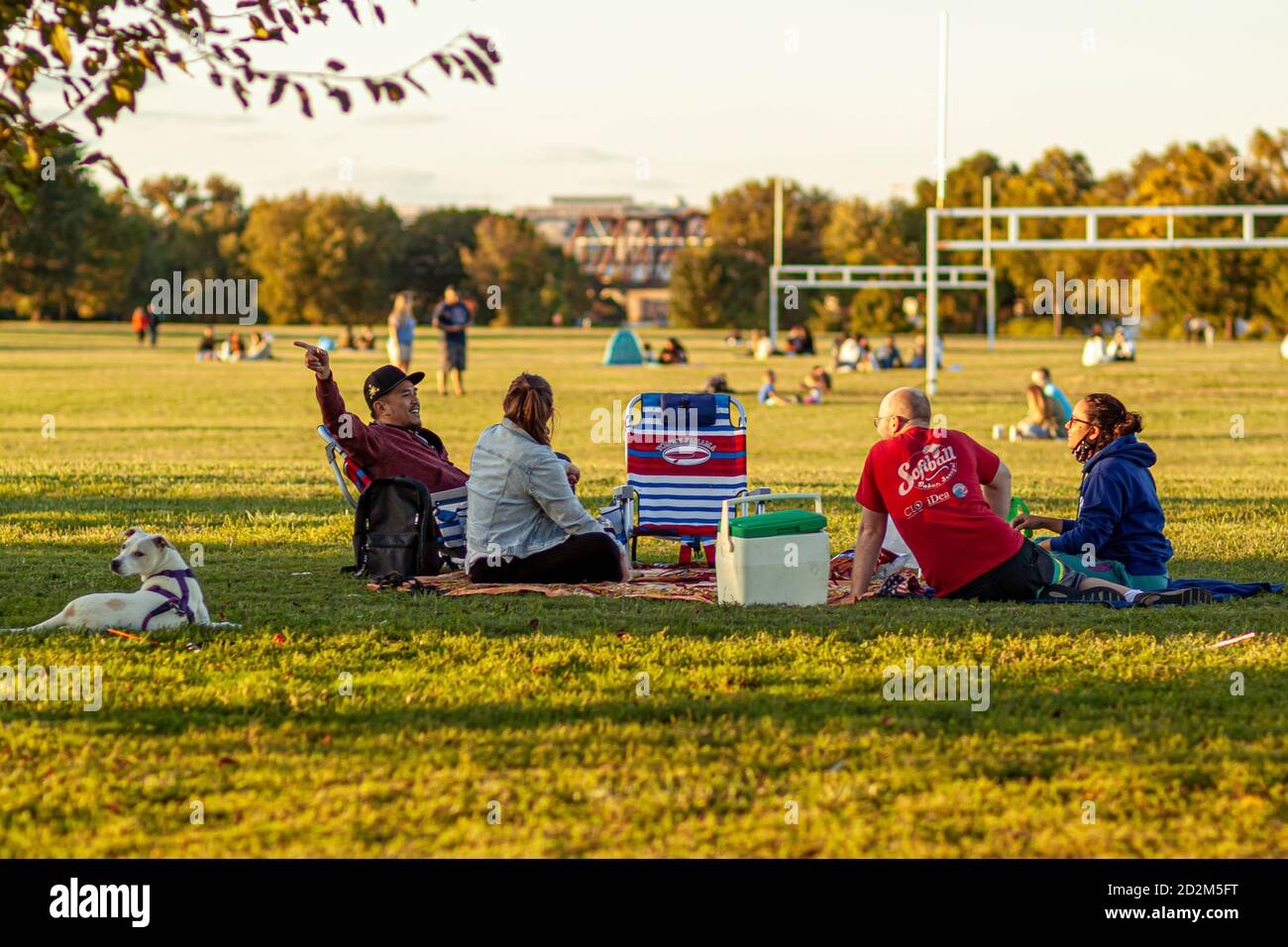 Arlington, va, USA 10/02/2020: Un groupe multiracial de jeunes sont assis sur des chaises pliables ou des draps sur le terrain d'herbe du parc de Gravelly point. TH Banque D'Images