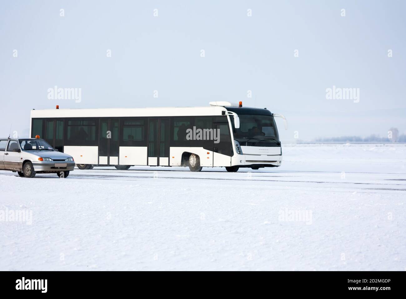 Bus de l'aéroport et voiture sur le tablier d'hiver Banque D'Images