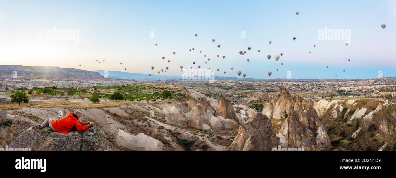 Un homme prend des photos de ballons dans le ciel au-dessus de Cappadoce Banque D'Images