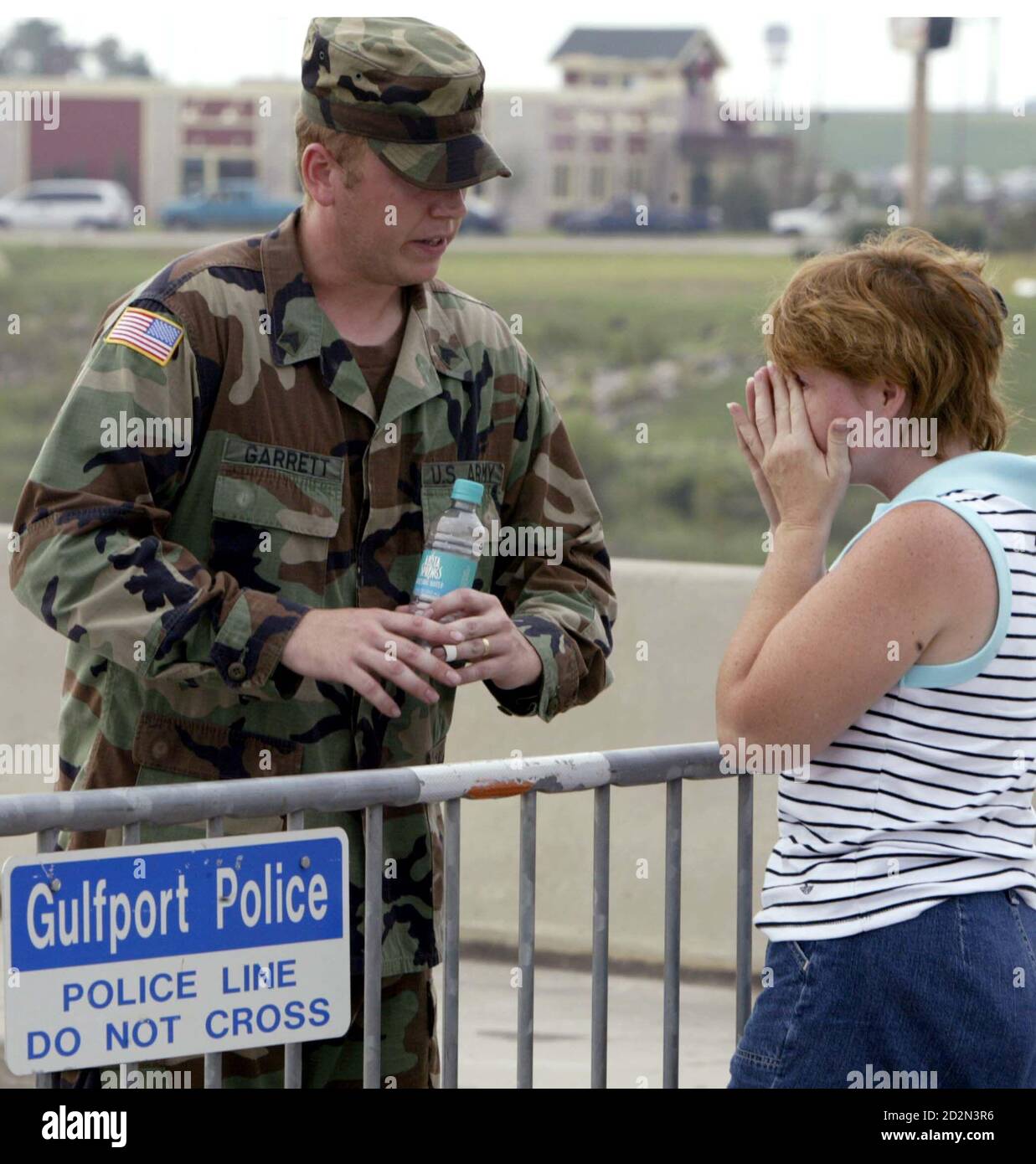 Sgt. Bryan Garrett (L), of the 204th Air Defense Artillery company, tells  Tammy Parker she has to wait in line as she tries to get in to receive the  ice and water