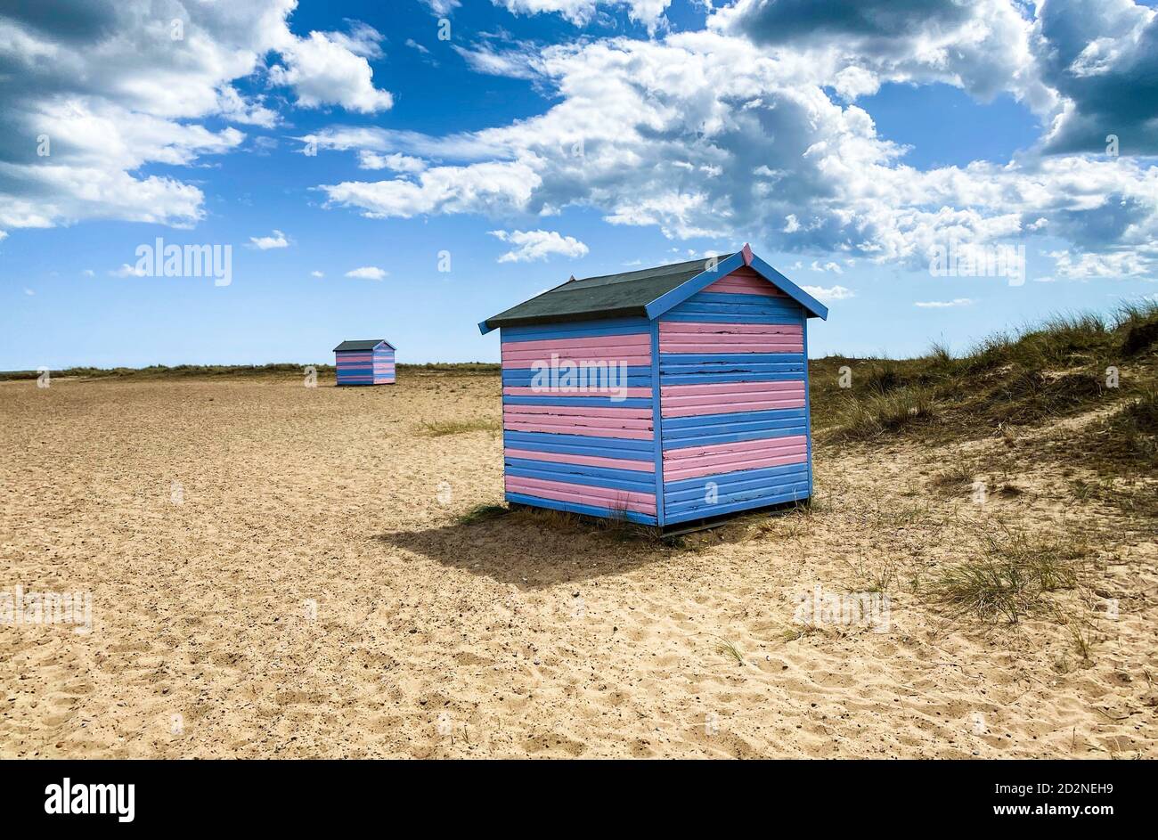 Cabines de plage Great Yarmouth en été, cabine britannique traditionnelle sur une côte est anglaise, bandes horizontales bleues et roses, ciel avec nuages Banque D'Images