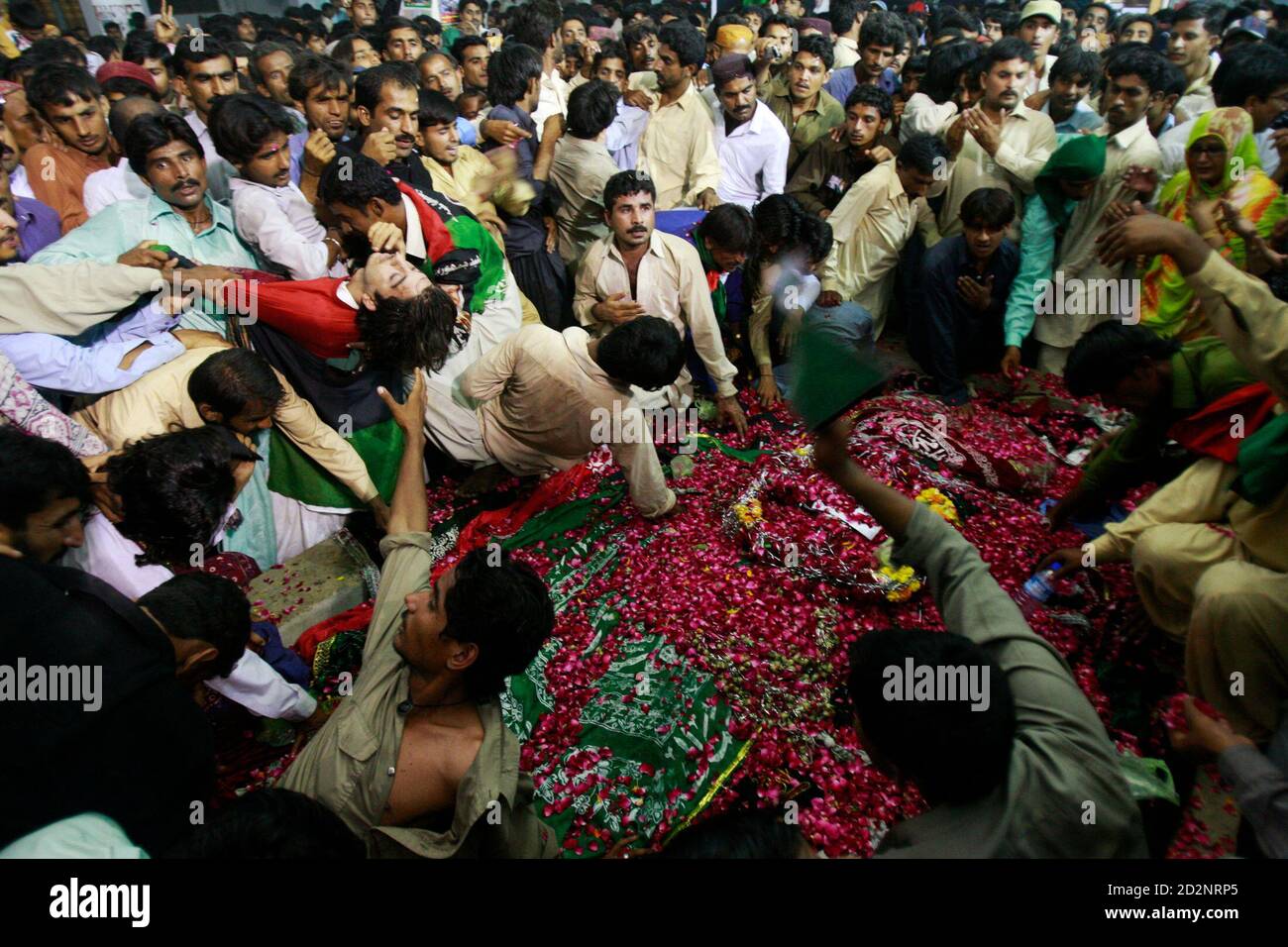 Supporters of Pakistan's slain former premier Benazir Bhutto mourn on her grave at Bhutto's family mausoleum in Garhi Khuda Bukash near Larkana April 3, 2009, on the eve of her father Zulfiqar