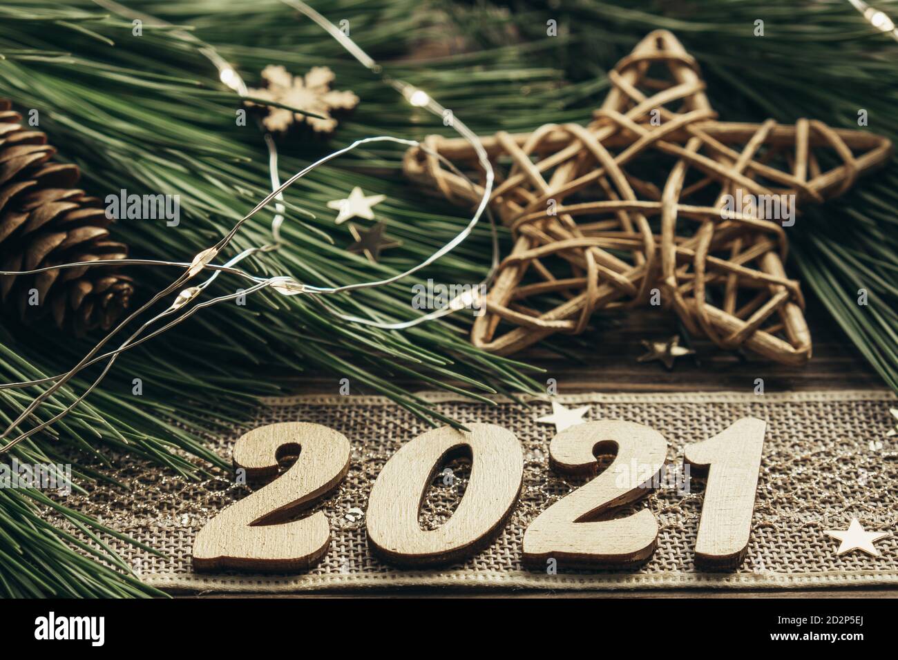 Branches de sapin aux numéros dorés, ruban vintage, guirlande et décorations sur fond de bois. Nouvelle année 2021. Fond de Noël festif.Lay plat Banque D'Images