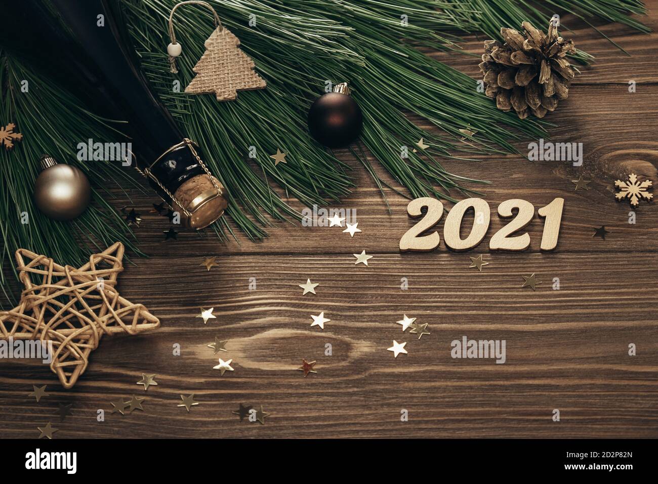 Nouvelle année 2021. Branches de sapin avec numéros dorés, champagne et décorations sur fond de bois. Fond de Noël festif. Copier l'espace. Pose à plat. Banque D'Images