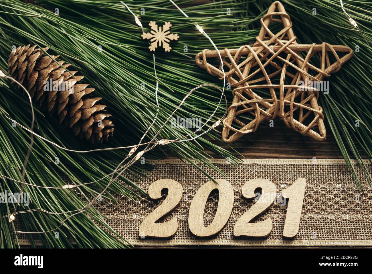 Branches de sapin aux numéros dorés, ruban vintage, guirlande et décorations sur fond de bois. Nouvelle année 2021. Fond de Noël festif.Lay plat Banque D'Images