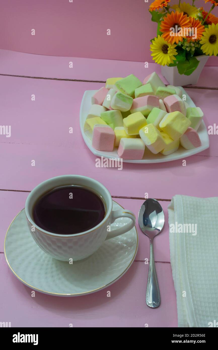 Une tasse de café le matin sur une table en bois rose et de délicieux guimauves. Le concept de petit déjeuner romantique, tendresse, Bonjour. Banque D'Images