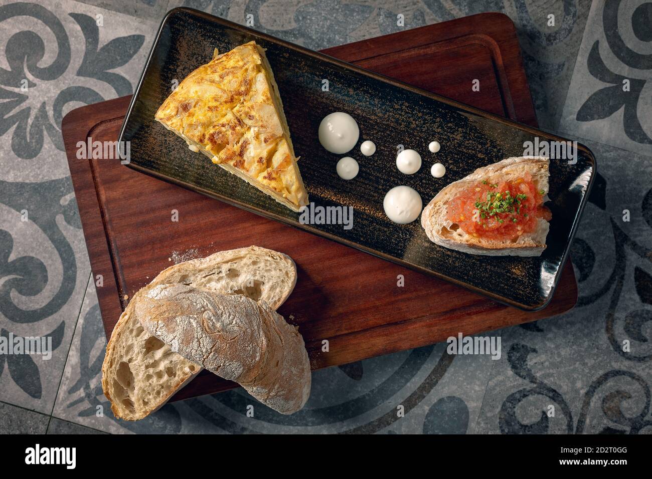 Omelette espagnole servie avec un peu de crème et pain avec tapenade de tomates Banque D'Images