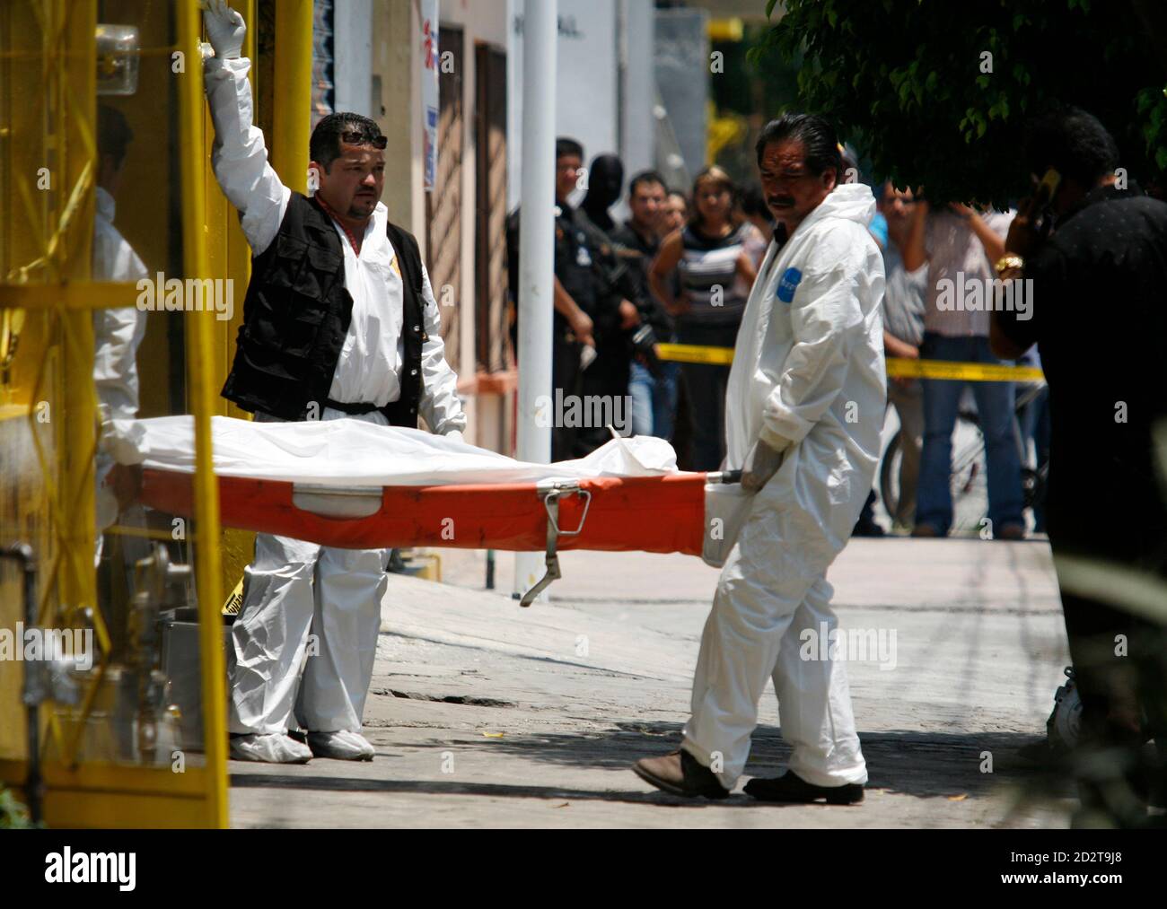 Les médecins légistes portent le corps d'un homme abattu à l'intérieur de son garage dans la ville d'affaires de Monterrey le 18 juin 2007. La police soupçonne que le meurtre était lié à des activités de gangs de drogue. Les victimes des meurtres de gangs de drogue dans la ville sont près de 83 personnes cette année, contre 55 pour l'ensemble de l'année 2006. REUTERS/Tomas Bravo (MEXIQUE) Banque D'Images
