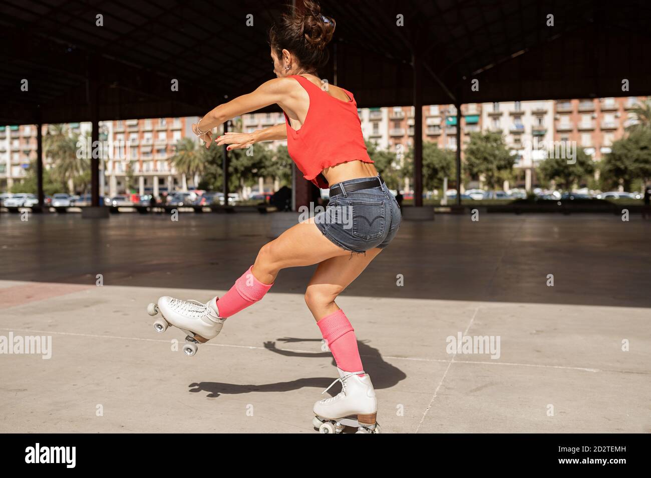 Concentration de l'équilibre féminin sur la jambe pendant le patinage à roulettes sur le sport terrain par jour ensoleillé en ville Banque D'Images