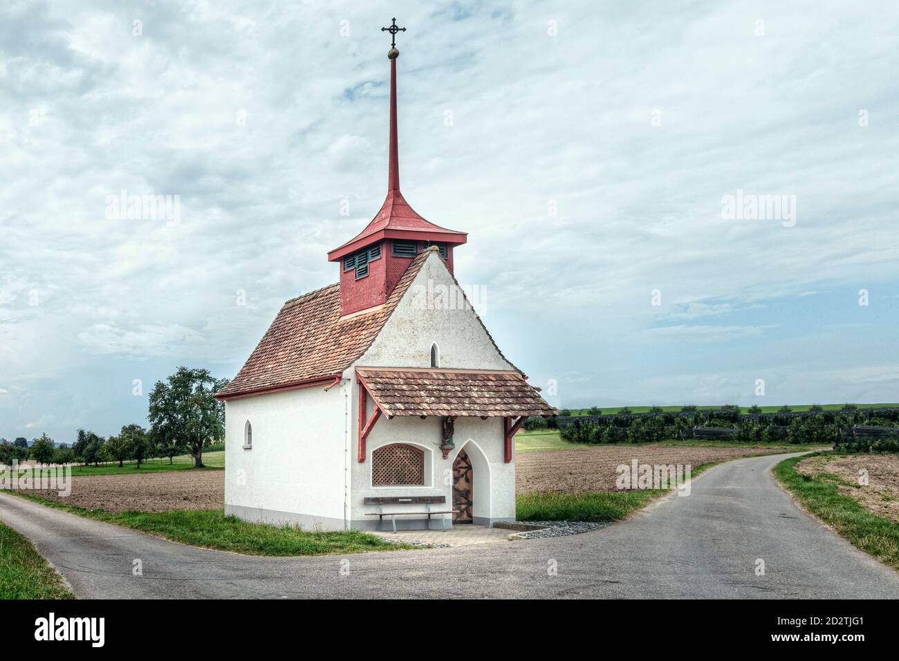 une chapelle au toit rouge sur les champs ruraux Banque D'Images