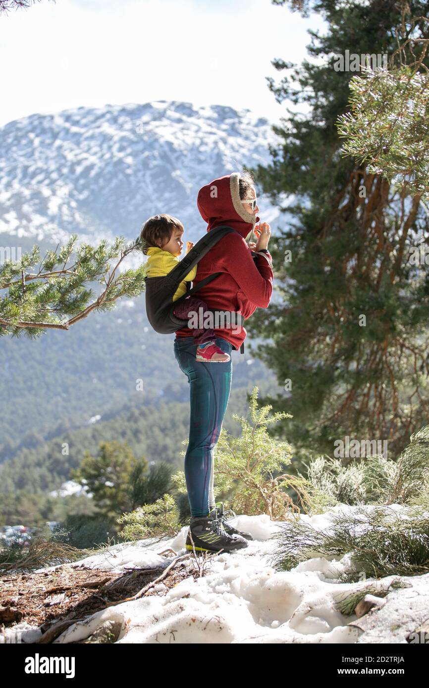 Vue Laterale De La Femme Avec Enfant Dans Le Porte Bebe Derriere Dos Debout Sur La Colline Dans Les Hautes Terres Le Jour Ensoleille A L Interieur Hiver Photo Stock Alamy