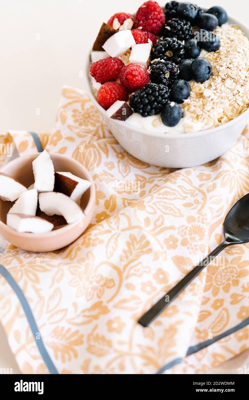 Grand angle de bol nutritif avec muesli et diverses baies dans un bol placé sur la table avec une serviette pour le petit déjeuner matin Banque D'Images