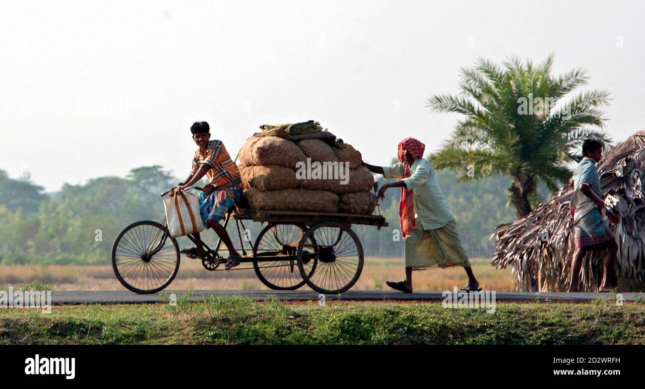 Les agriculteurs transportent leurs produits sur un marché du village de Nandigram, à environ 170 km (105 miles) au sud-ouest de la ville indienne de Kolkata, dans l'est du pays, le 21 novembre 2007. Pour ces villageois, de la mâchoire de la victoire est venu une défaite bien pire. Lorsque le gouvernement communiste du Bengale occidental a fait marche arrière sur la saisie de leurs terres pour un complexe industriel, il a été considéré comme une victoire pour les agriculteurs pauvres s'opposant au jongleur imparable que l'économie du géant asiatique semble être. Mais maintenant, les routes de boue habituellement animées qui traversent des dizaines de villages à Nandigram sont désertes et la zone parsemée de fla communiste rouge Banque D'Images