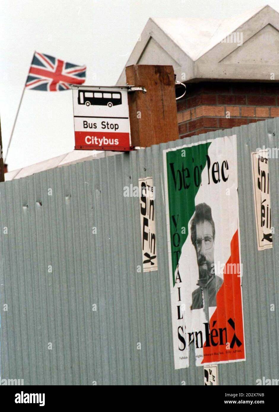 Une affiche Sinn Fein représentant le visage de Gerry Adams sur une barricade séparant une zone nationaliste d'une zone loyaliste (volant de l'Union Jack) à Belfast aujourd'hui (Sam) photo de Stefan Rousseau. Banque D'Images