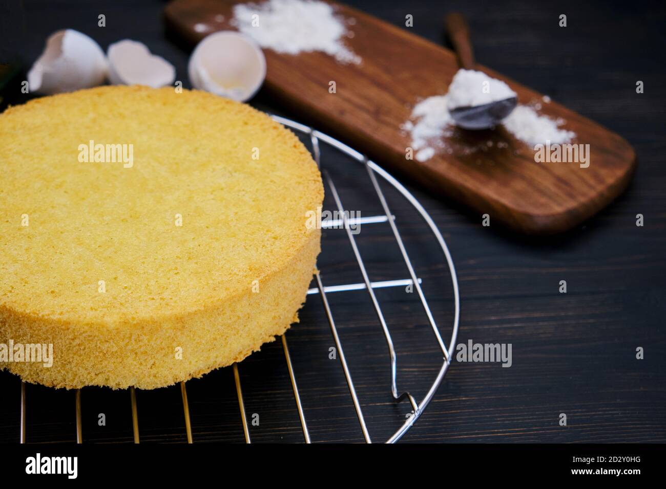 Râtelier à gâteau éponge, farine et œufs. Ingrédients pour cuire des biscuits sur fond noir Banque D'Images