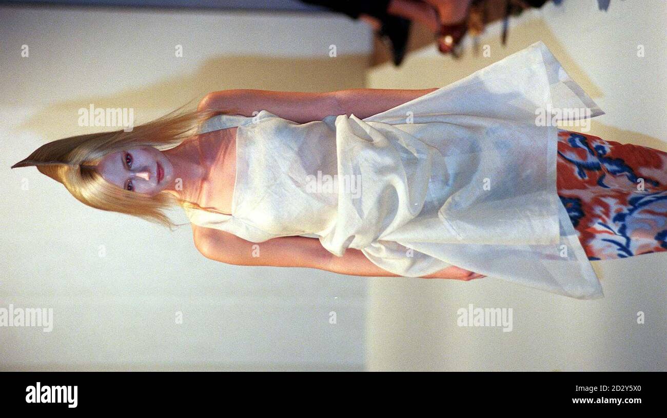 Un mannequin porte une robe à dos nu blanche sur une paire de pantalons en soie à motifs par le designer Kosuke Tsumura Today (dimanche) pendant la Fashion week de Londres.Photo de Neil Munns/PA. Banque D'Images