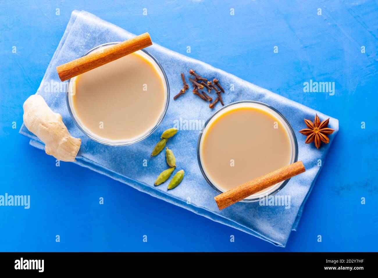 Thé Chai de masala. Boisson traditionnelle indienne - thé masala avec diverses épices. Verre de thé masala sur fond bleu Banque D'Images