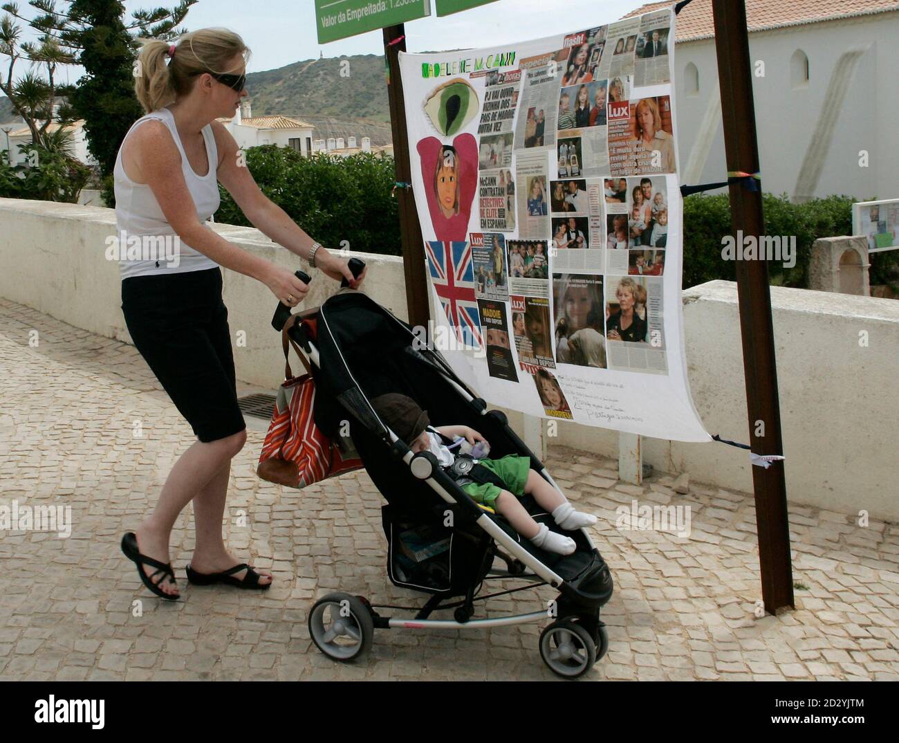 A Woman With A Child Looks At Posters About Missing British Girl Madeleine Mccann In Praia Da Luz Southern Portugal May 3 08 Madeleine Mccann Vanished From The Family Holiday Apartment In