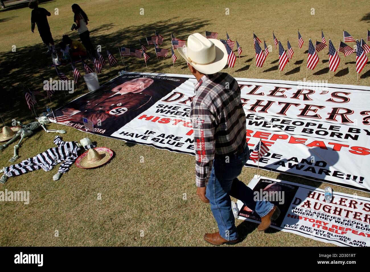 A man protesting against Senate Bill 1070 looks at a banner depicting  Arizona's Governor Jan Brewer as a Nazi outside the Arizona State Capitol  in Phoenix, Arizona April 29, 2010. Civil rights