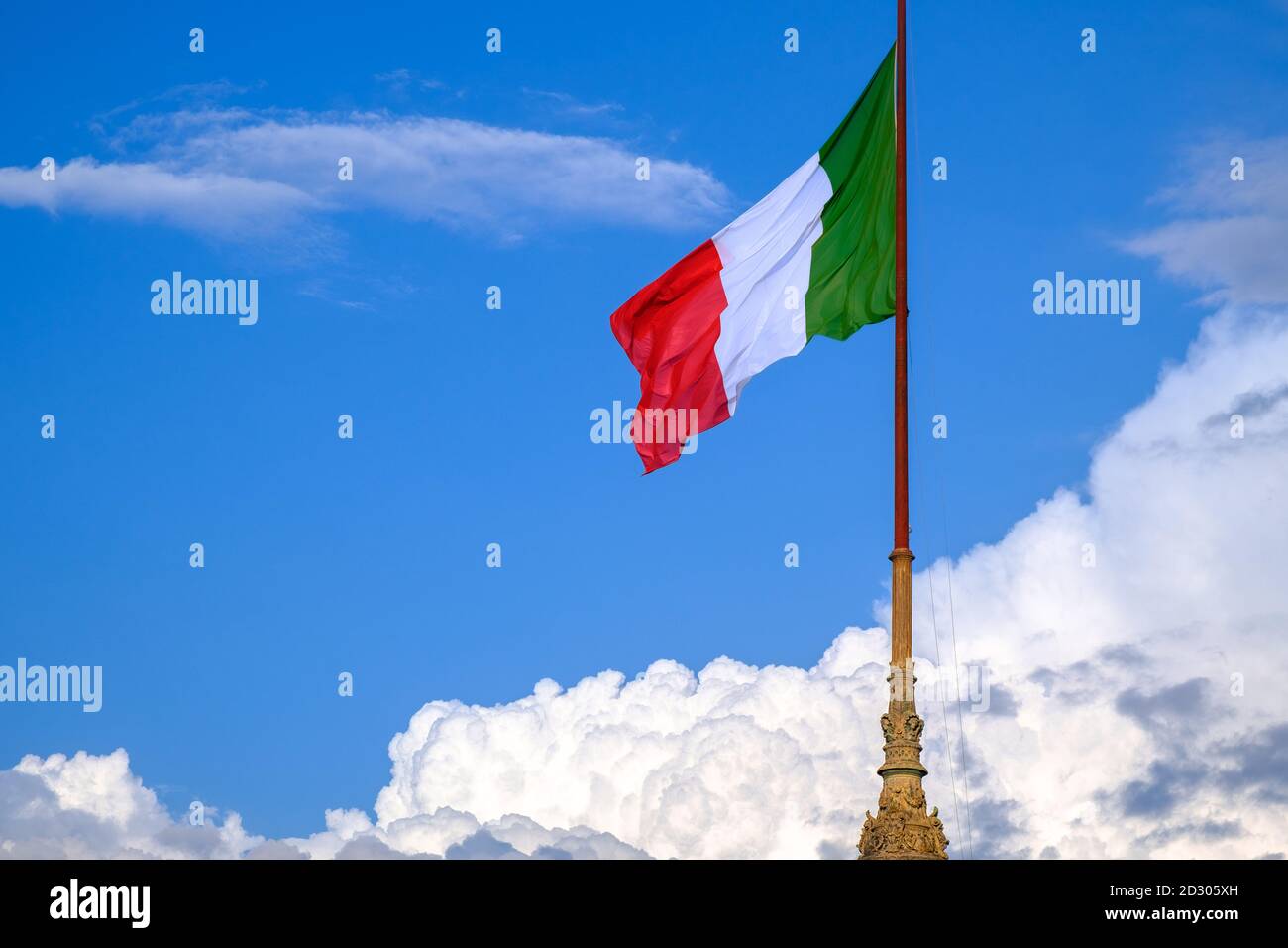 Le drapeau de l'Italie se dresse fièrement avec un ciel bleu sur le fond encadré par des nuages. Image symbolique de la Journée nationale italienne et de la Fête de la République le 2 juin Banque D'Images