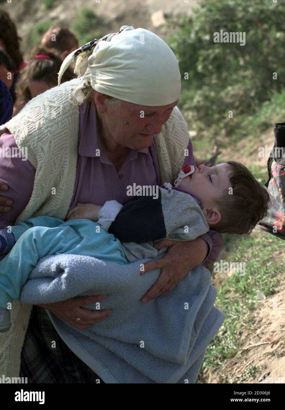 Une vieille femme avec un enfant se prépare à quitter le passage frontalier de Blace alors que le Premier ministre britannique Tony Blair est arrivé, où il a rencontré des réfugiés du Kosovo bloqués dans des terres sans homme, en attendant l'autorisation d'entrée en Macédoine. Banque D'Images