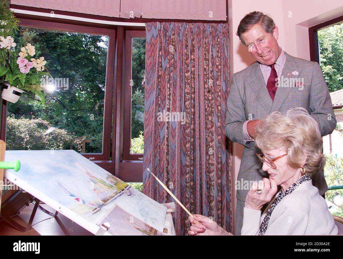 Le Prince de Galles rit avec Jenny Iannucci, une autre passionnée de peinture, une patiente en garderie à l'hôpital Earl Mountbatten, près de Newport, lors de sa visite à l'île de Wight. Le prince a également visité les tombes de ses arrière-grands-parents. * Prince Louis de Battenberg et Princesse Victoria de Hesse. Banque D'Images