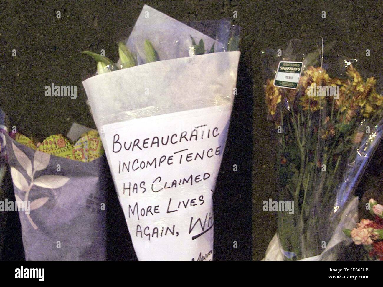 Des mots forts sont affichés sur un hommage floral déposé sur la scène de l'accident ferroviaire de Ladbroke Grove à Londres. Des enquêtes se poursuivent sur l'accident de train survenu mardi à l'ouest de la gare de Paddington à Londres, où le nombre de morts pourrait atteindre 100. Banque D'Images