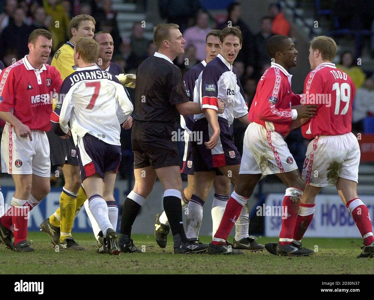 L'arbitre Graham Poll (au centre, chemise noire) est entouré par les joueurs de Charlton Athletic et Bolton Wanderers, après avoir envoyé Dean Holden de Bolton lors de leur match de football FA Cup Quarter final au Reebok Stadium, Bolton. Banque D'Images