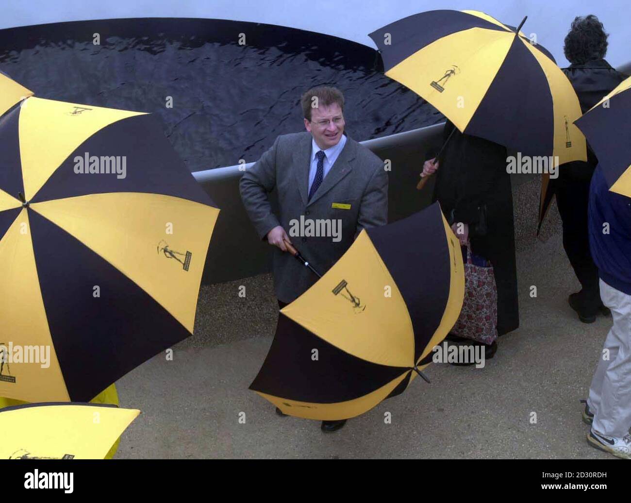 Chef de l'exécutif du Dôme du millénaire Pierre-Yves Gerbeau, abris de la pluie devant la sculpture d'Anish Kapoor, « eaux paraboliques », au Dome de Londres, où près de 20 œuvres d'art ont été dévoilées au public. *les œuvres se trouvent dans les zones du Dôme, dans les jardins du Millénaire, sur le quai Queen Elizabeth II et dans la Tamise elle-même. Le coût de la mise en service des œuvres d'art était prévu dans le budget de construction et de fonctionnement du Dome de 7 58 millions. Banque D'Images