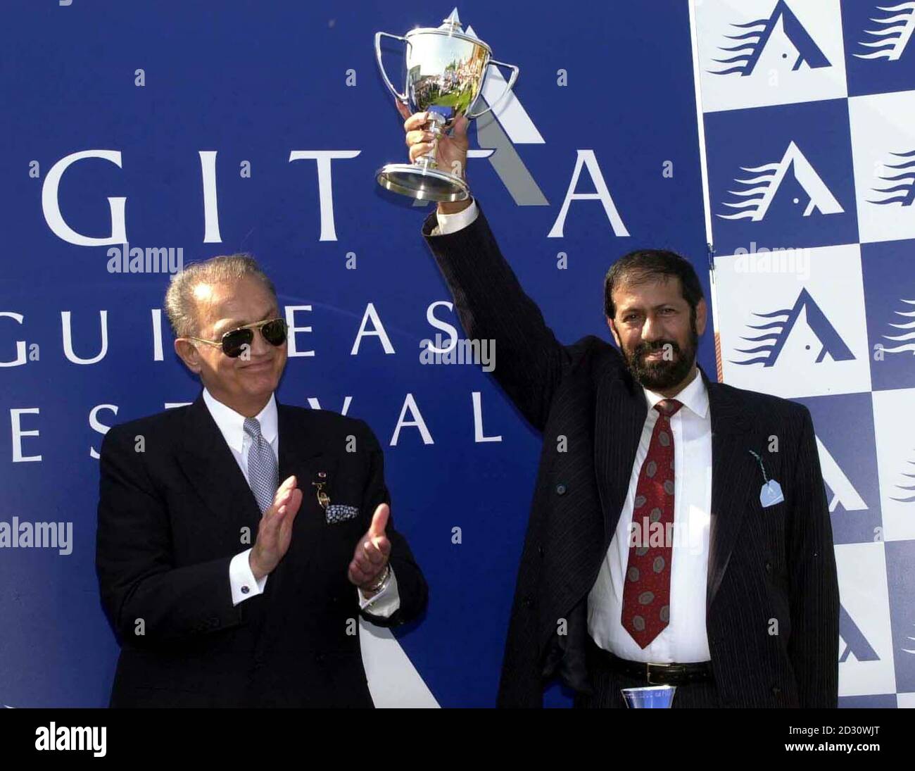 WAFIC Said (L), Président de Sagitta, présente le trophée guinéen 2000 à Saheed Suhail, propriétaire du cheval gagnant 'King's Best' à Newmarket. R/I: 12/3/01. Banque D'Images