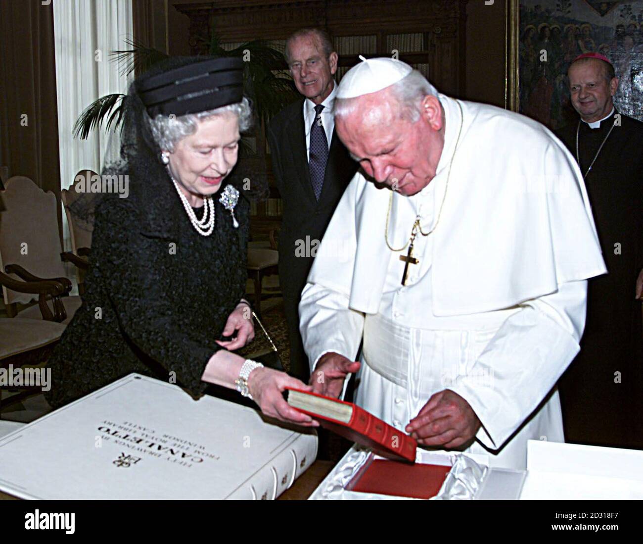 Les échanges de la reine Elizabeth II de Grande-Bretagne se présentent avec le pape Jean-Paul II lors d'un auditoire au Vatican à Rome, en Italie. *vêtue de noir et vêtue d'un voile, la Reine a été accueillie par le chef de l'Église catholique romaine, âgé de 80 ans, à la porte de son étude. Au cours d'une réunion privée de 20 minutes, on pense qu'ils ont discuté des progrès vers l'unité chrétienne et des problèmes en Irlande du Nord. La Reine est arrivée à Rome lundi au début d'une visite d'État de quatre jours en Italie. Banque D'Images