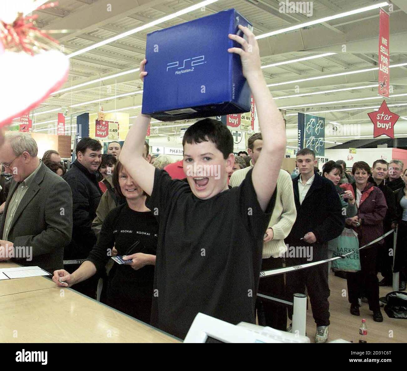 Joe Jones, âgé de 14 ans, présente sa nouvelle PlayStation 2 au magasin Kingston Park Tesco de Newcastle. Joe a mis la file d'attente pendant six heures et a été la première personne à obtenir l'une des nouvelles consoles de jeux au magasin. Banque D'Images