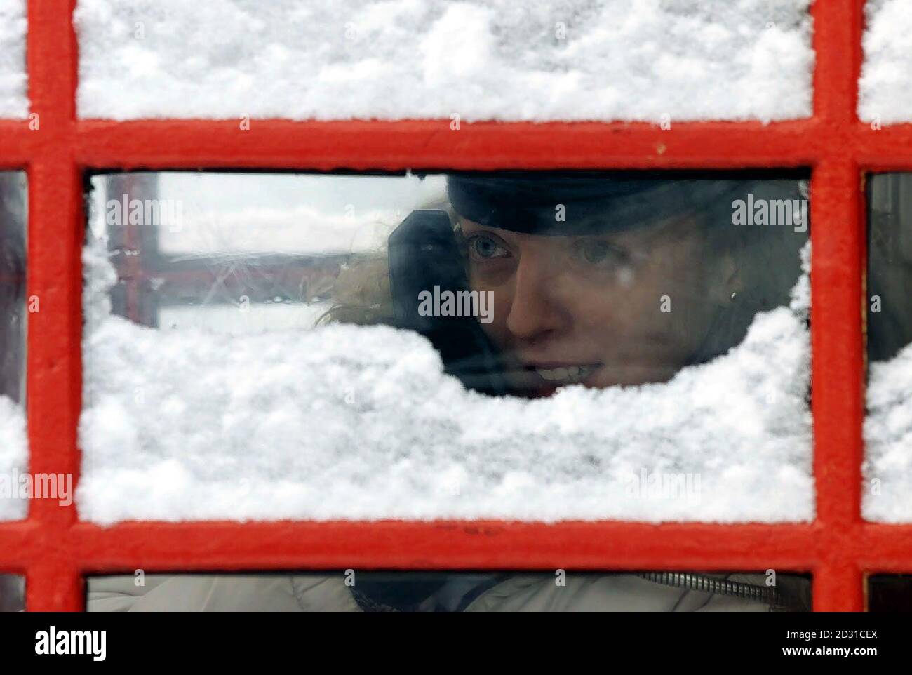 Un membre du public brave la neige à Manchester pour faire un faux-filet à partir d’une boîte téléphonique publique, après que la neige et la luge aient balayé une grande partie de la Grande-Bretagne pendant la nuit. Les conditions de gel menacent le chaos sur les routes lorsque des millions de navetteurs se redirigent vers le travail. * six pouces de neige sont tombés dans certaines parties du pays de Galles alors que les conditions arctiques se déplaceraient vers l'est à travers le pays, blankant les Midlands, le West Country et Gloucestershire. Banque D'Images