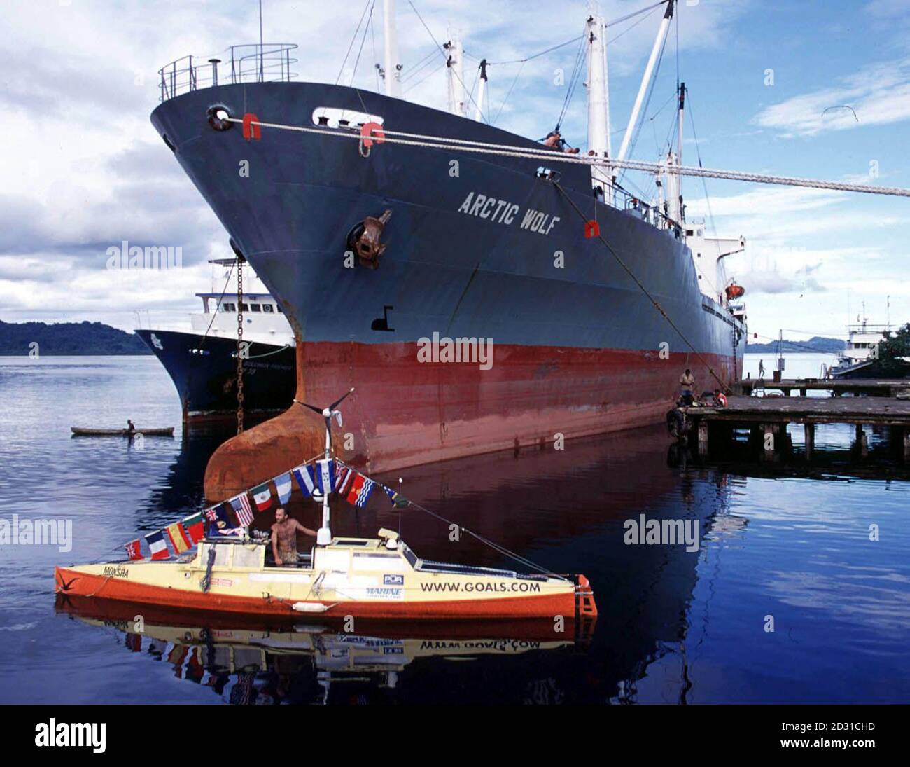 L'aventurier Jason Lewis dans le bateau Moksha en face d'un pétrolier dans les îles Salomon. Deux Britanniques sont invités à se joindre à Jason pour un voyage unique en mer terrestre, alimenté par l'homme, autour du monde. * l'odyssée de M. Lewis a atteint l'Australie après avoir pris six ans pour compléter 20,000 miles de son objectif estimé de 35,000 miles. La prochaine étape l'emportera ainsi qu'un groupe de cinq compagnons lors d'un marathon de vélo tout terrain de 100 jours et de 4,000 miles au cœur de l'Australie. Jason, âgé de 32 ans, de Bridport, Dorset, a traversé la Manche, les océans Atlantique et Pacifique, et a fait des rollers à travers les États-Unis Banque D'Images