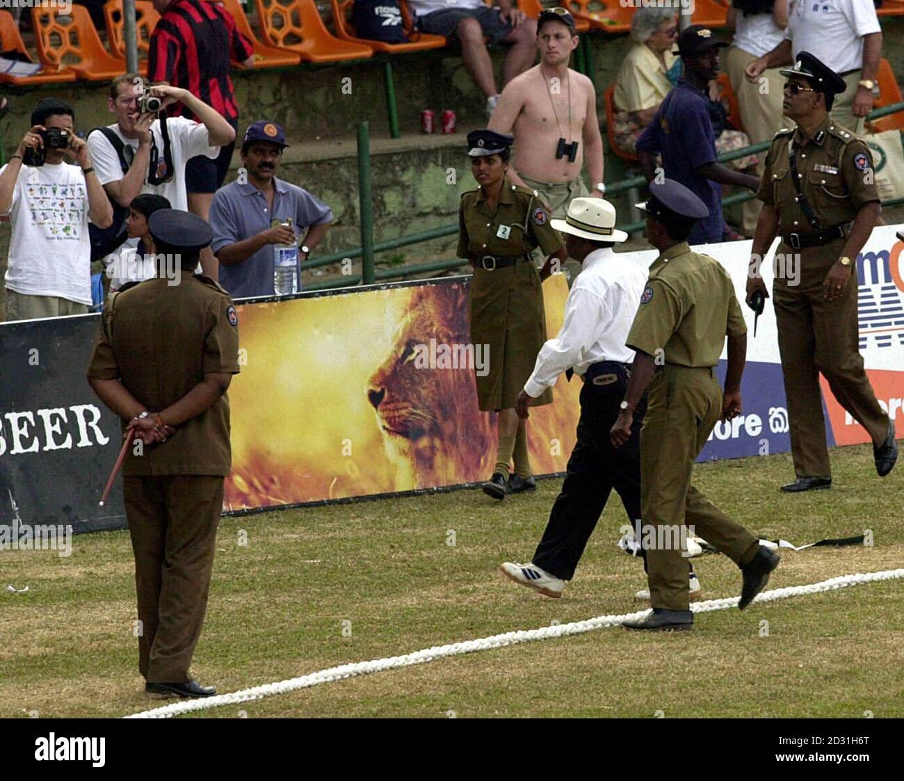 L'arbitre sri-lankais C.-B. Cooray reçoit une escorte de police alors qu'il quitte le terrain à la fin du troisième jour du 2e Test entre le Sri Lanka et l'Angleterre au stade Asgiriya, à Kandy, au Sri Lanka. Banque D'Images