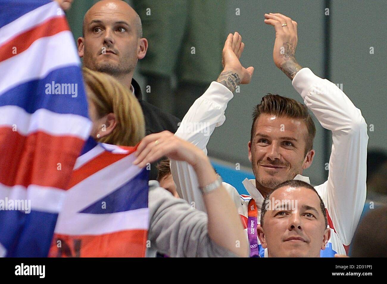 David Beckham applaudit Tom Daley, en Grande-Bretagne, alors qu'il célèbre sa médaille de bronze lors de la finale de la plate-forme hommes de 10 m au centre aquatique, le 15 e jour des Jeux Olympiques de Londres en 2012. Banque D'Images