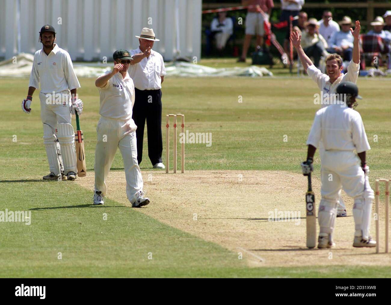 Animul Islam (à l'extrême droite) du MCC XI est rejeté par Damien Martyn (deuxième à droite) en Australie, le capitaine du MCC XI, Jimmy Adams (à l'extrême gauche), regardant, au Arundel Castle cricket Club, West Sussex. Banque D'Images