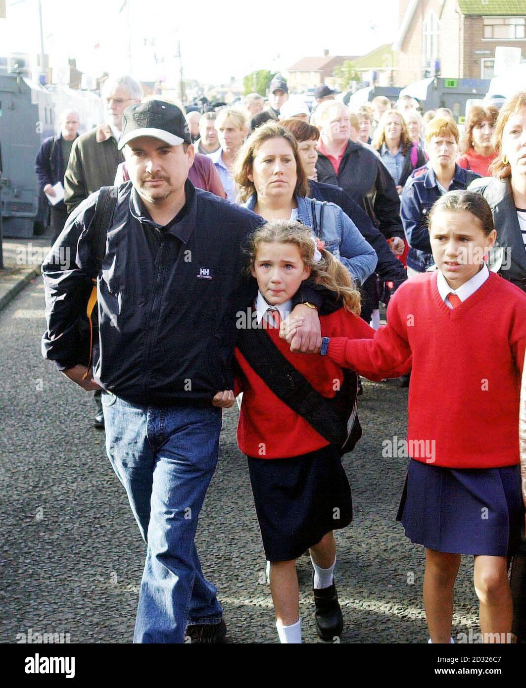 Les parents catholiques escortent leurs enfants avec des officiers de RUC en tenue d'émeute à l'école Sainte Croix de Belfast. Le quatrième jour de troubles dans la région nord de Belfast, les parents se sont engagés à ne pas emmener leurs enfants à l'école après avoir reçu une menace de mort de la part des fidèles. Banque D'Images