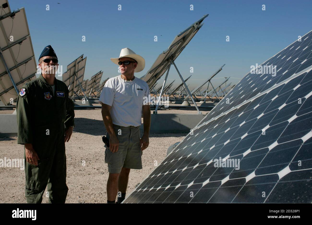 Col. Dave Belote (L), commander of Nellis Air Force Base, looks at an array  of solar photovoltaic panels with Eric Vander Leest, a photovoltaic system  technician for SunPower Corp., at the base