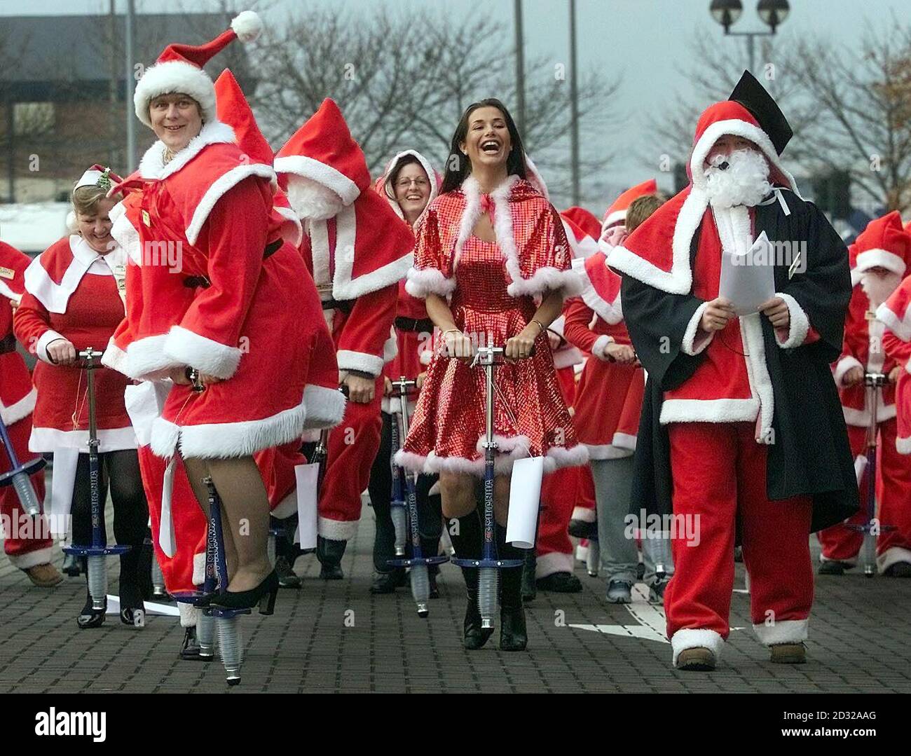 Les ouvriers des supermarchés s'habillent comme des clauses de Santa et apprennent à pogo à leur siège social de Leeds. Asda a eu l'idée de livrer des cadeaux sur des bâtons de pogo en raison des restrictions sur leur transport habituel de rennes après la crise du pied et de la bouche de cette année. Banque D'Images