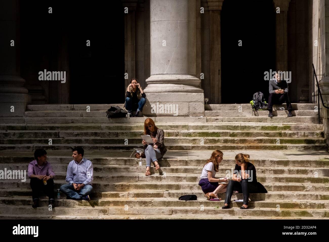 Le soleil du milieu de l'après-midi sur les marches de l'église Saint-Jean Smith Square attire les gens à venir s'asseoir et profiter de la chaleur et s'engager dans la conversation ou simplement s'asseoir par eux-mêmes. 05 juin 2014. Photo: Neil Turner Banque D'Images