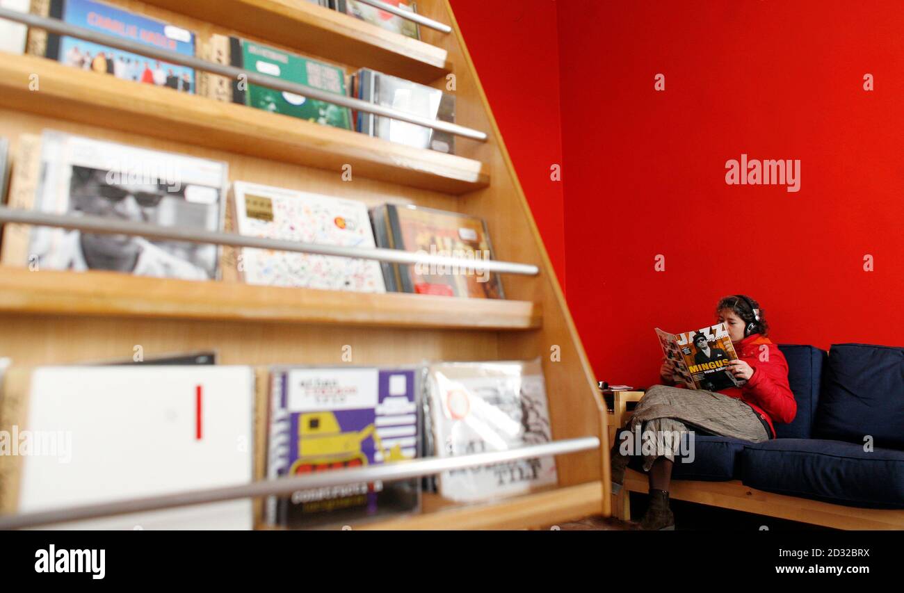 A woman reads a magazine while she listens to a jazz CD ...