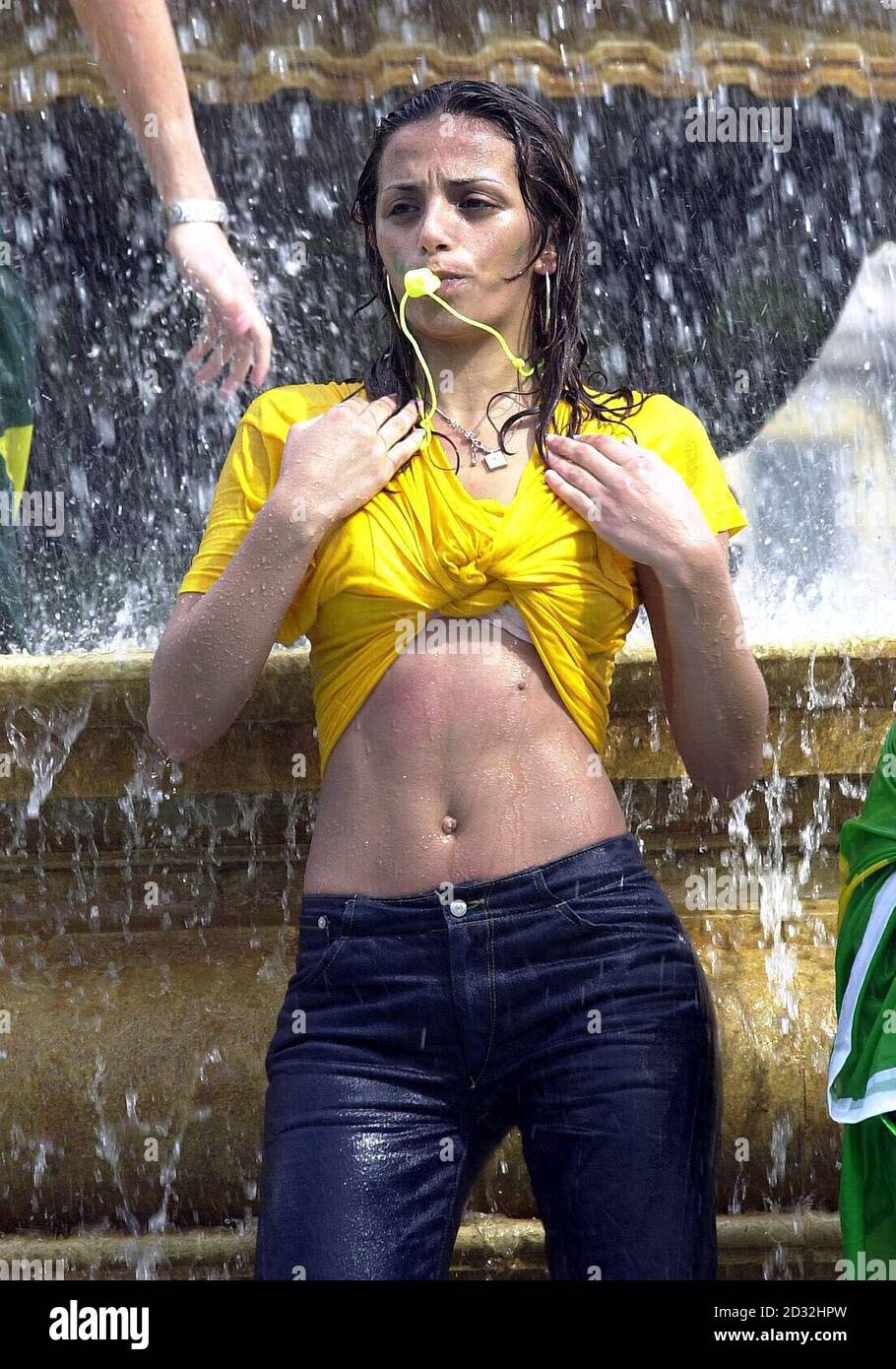 Un jeune fan brésilien célèbre dans une fontaine de Trafalgar Square, à Londres. Le Brésil a battu l'Allemagne 2-0 à Yokohama, au Japon pour remporter la coupe du monde pour la cinquième fois, Ronaldo marquant deux fois dans la seconde moitié pour donner sa victoire d'équipe. Banque D'Images