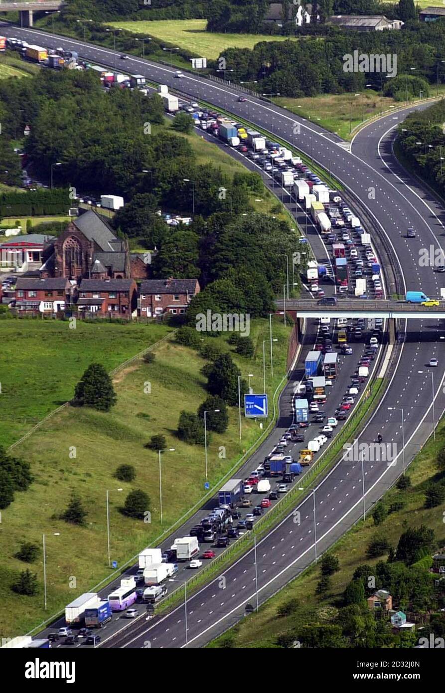 Des files d'attente massives ont été causées après que la police ait fermé l'autoroute M6 près de Wigan lundi 8 juillet 2002, après un incident au cours duquel des officiers ont tiré et blessé un homme armé qui les avait menacés de ce qui était censé être une arme à feu.* l'homme a été transporté à l'hôpital où son état n'est pas considéré comme mettant la vie en danger.Des officiers de la police du Grand Manchester et de la police de Merseyside avaient été appelés juste avant 0400 pour faire état d'un homme armé d'une arme à feu près de la jonction 26 de l'autoroute M6 à Wigan, dans le Grand Manchester. Banque D'Images