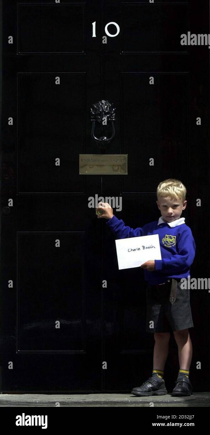 James Barnes-Austin, 5 ans, remet une lettre à Cherie Booth, à la célèbre porte du 10 Downing Street, Londres. Il a écrit une lettre pour demander que son école, Three Bridges First School, Crawley, dans West Sussex, soit épargnée par une fusion de réduction des coûts. * James a été décrit comme un bébé tenu par Tony Blair dans la campagne électorale de 1997. Banque D'Images