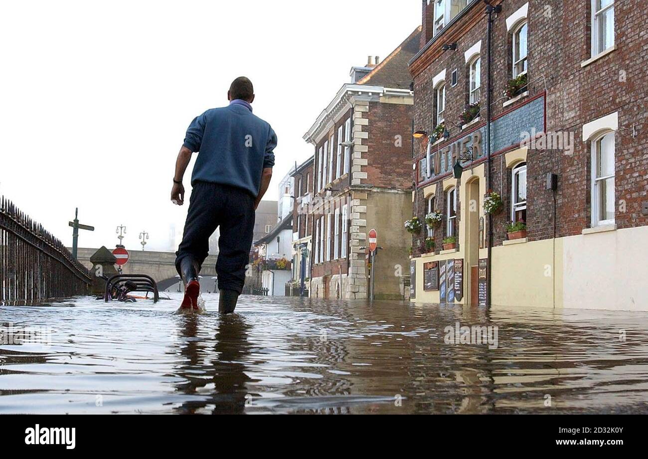 Un homme se démène dans une rue inondée de la ville de York. Les résidents de Riverside, habitués aux inondations pendant la saison d'hiver, se trouvent maintenant gravement touchés par les pluies torrentielles au plus fort de la saison d'été. Banque D'Images